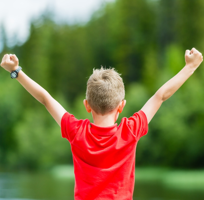 A boy with his hands in the air.