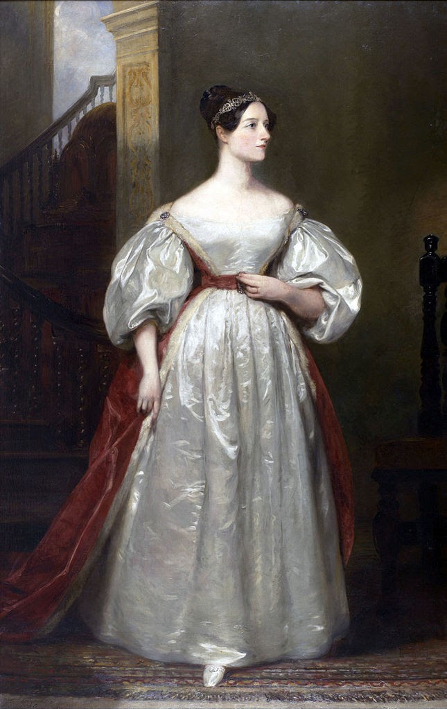 Ada Lovelace first computer programmer standing for a portrait wearing a white dress with a red sash with her dark hair up and wearing a tiara